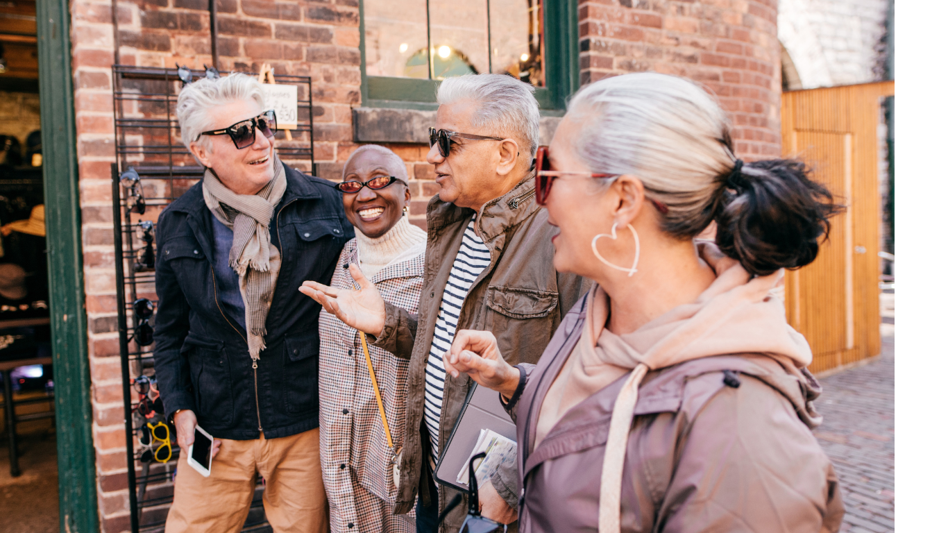 A group of older adults dressed warmly outside a brick downtown area