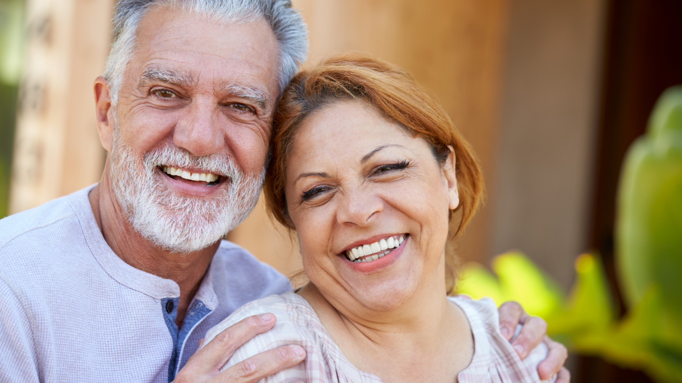 An older woman and an older man smile for a couples photo